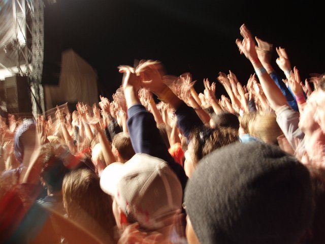 audience waving hands at a concert