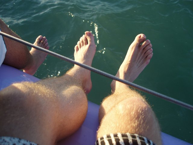 legs hanging over the side of a boat
