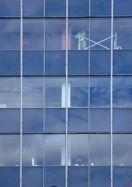 workers behind glass in a modern office building redecoration