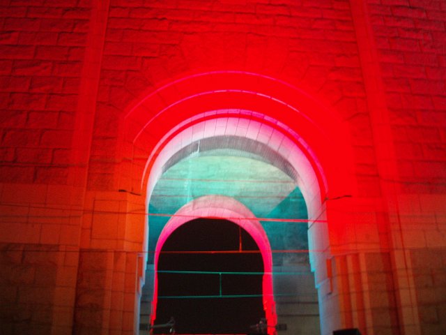 stone arch illuminated by brightly coloured lights