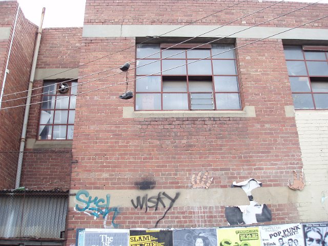 a narrow alley way, brick building and metal framed windows