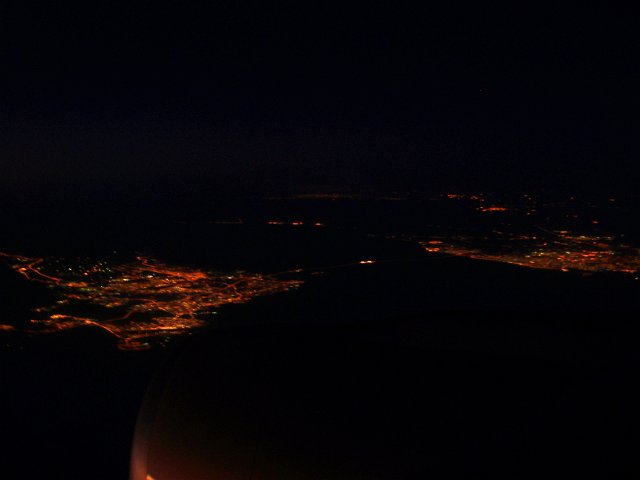 flying at high altitude looking down on cities at night
