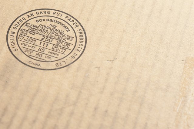 Close up of corrugated cardboard box with conformity stamp in corner and copy space