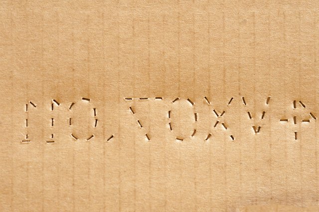 Abstract Background Close Up of Corrugated Cardboard with Backwards Perforated Serial Number, Brown Paper Box with Identification Number on Shipping Package