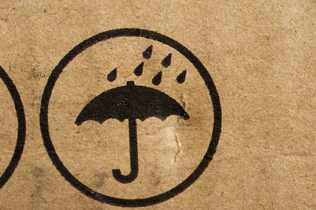 Do Not Get Wet icon stamped on brown cardboard packaging with an umbrella and shower of rain