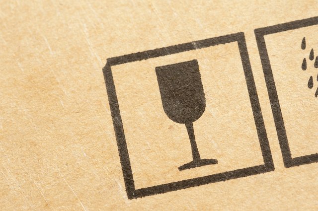 Glass icon stamped on a brown cardboard carton used for packaging indicating fragile or breakable contents
