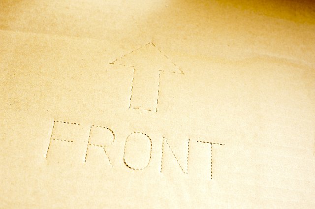 The word front with up arrow on corrugated cardboard as a background with copy space