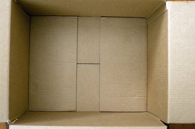 Inside an empty brown cardboard box for packing with an overhead close up view looking down inside the open flaps
