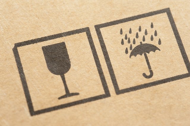 Close Up of Packaging Carton Symbols Showing Wine Glass and Umbrella with Rain - Fragile Contents, Protect from Moisture Icons Printed on Cardboard Box
