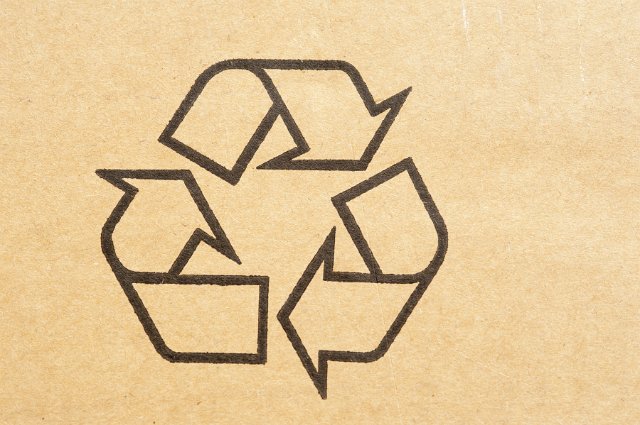 Recycle symbol stamped on a brown cardboard carton to be recycled and reused to save the environment from pollution