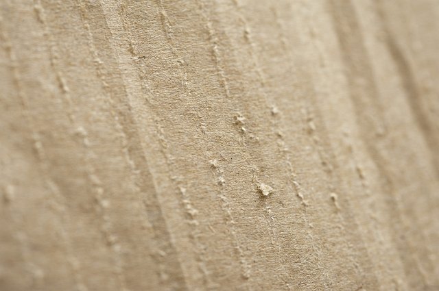 Background texture of brown paper or cardboard packaging with rough fiber detail in a close up overhead view