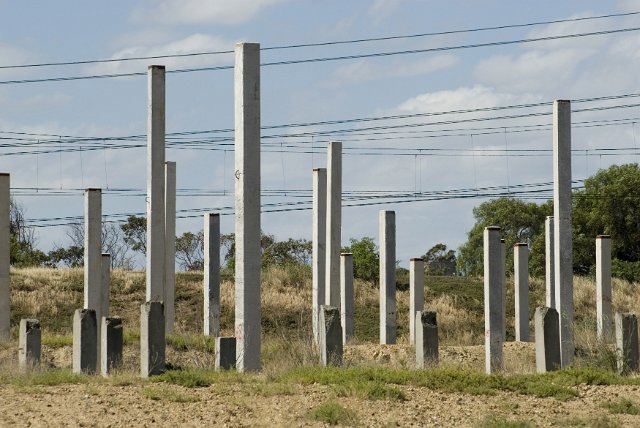 Concrete piles sticking out of the ground on abandoned construction site
