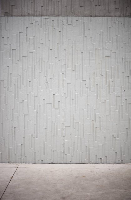 Concrete wall with decorative relief pattern of random geometric rectangles in an architectural background