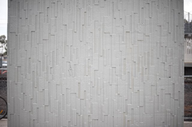 Exterior decorative textured concrete wall in a street with geometric rectangular pattern in relief