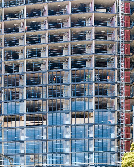 the front of a tall residential building being constructed