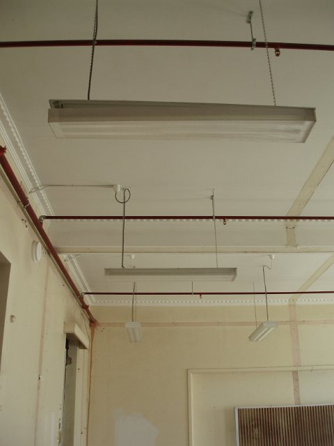 the ceiling and flourescent lights in an old derelict office building
