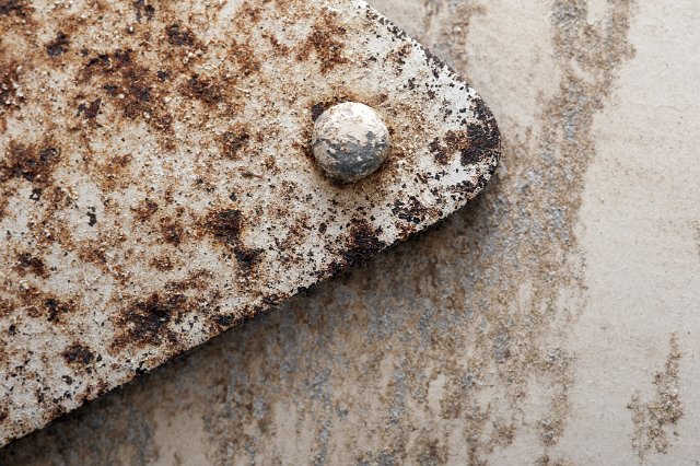 Old rusted industrial metal background texture with riveted panel, stains and corrosion in a full frame close up view