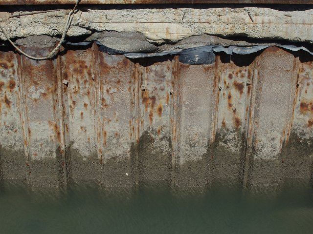 a rusty quayside made from metal pilings
