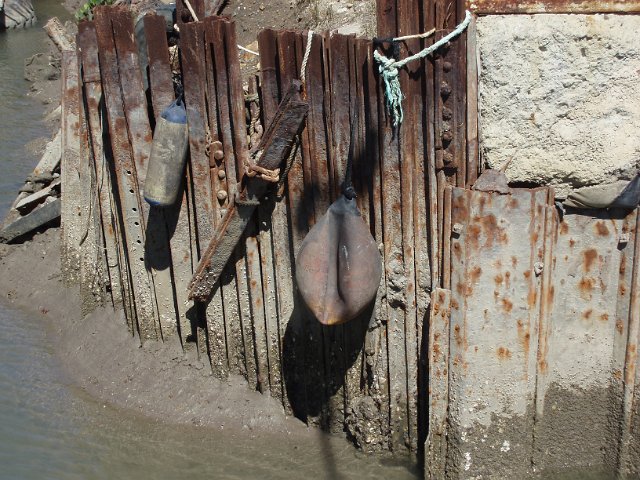 a rusty dock quayside made from metal pilings