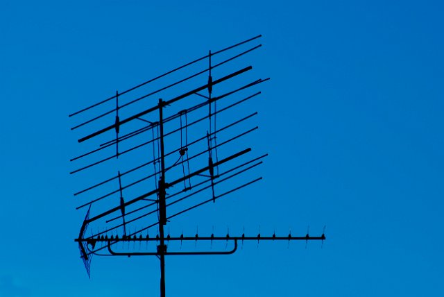 roof top antenna pictured against a deep blue sky