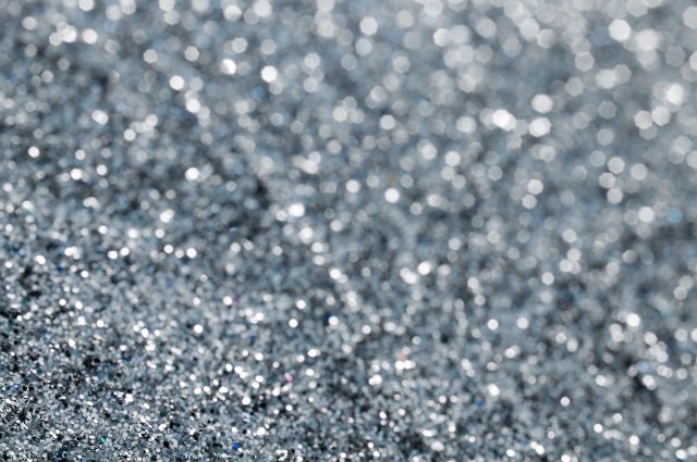 Grey gravel background with light sparkles slightly out of focus near top right corner