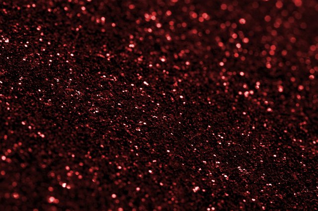 Sparkling festive dark red glitter texture for a holiday or festive celebration or a seasonal Christmas greeting, full frame view