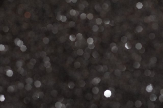 Full frame of blurry sparkling glitter in black space with copy space