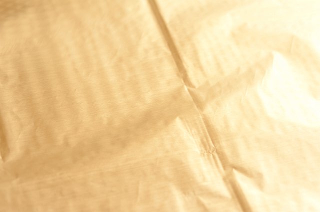 Full frame view of shiny gold metallic paper or material with creases visible