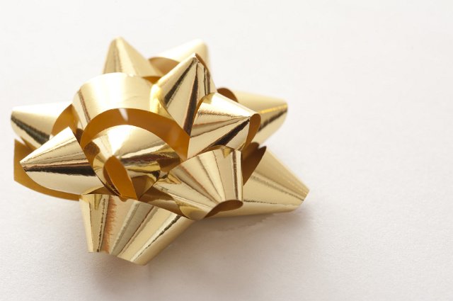 golden shiny gift wrap bow on a white backdrop