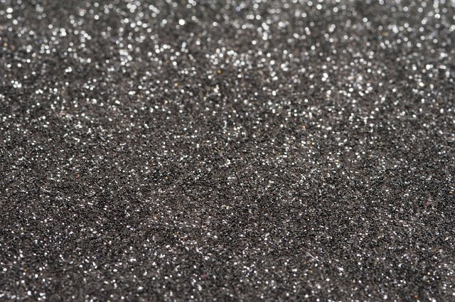 Glittering sliver grey surface background texture viewed from above in a full frame view for festive or holiday themed concepts