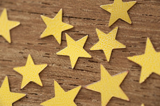 Concept Background Image of Golden Stars in Various Sizes Scattered on Wooden Background