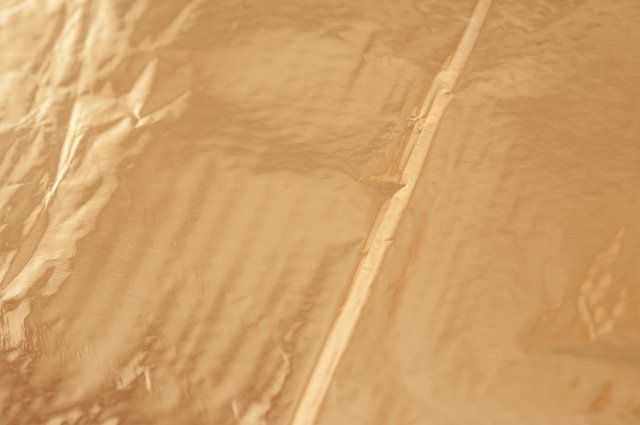 Full Frame Close Up of Abstract Metallic Gold Foil Background with Folds and Wrinkles