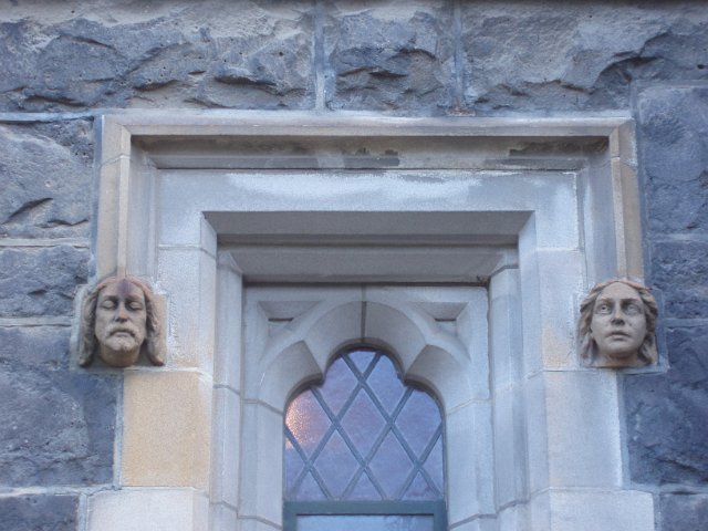 a church window with two stone grotesques