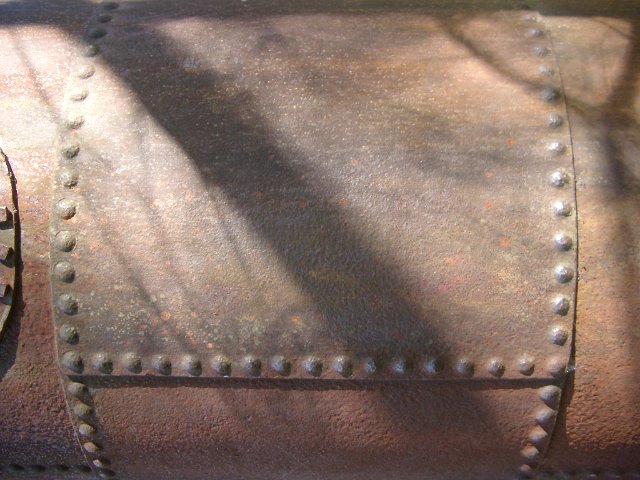 rivets on the outside of an old steam engine boiler