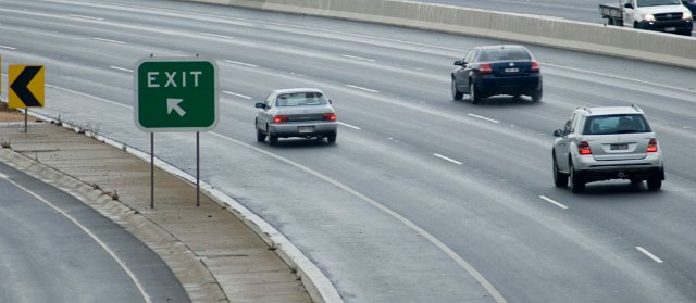 cars passing a freeway exit sign