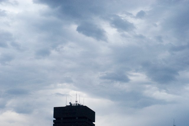 high contrast storm clouds and the top of a building
