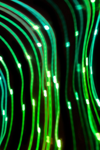 an abstract image of green light trails which emote electronic circuits or moving electrons