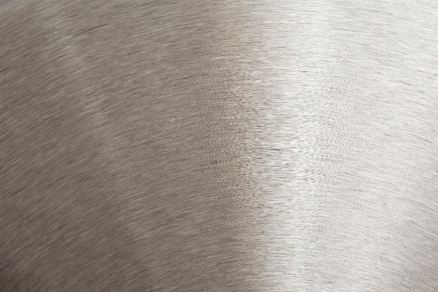Close up detail of a metallic, brushed steel surface.