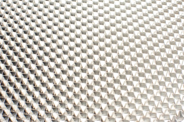 A close up of metal filter pattern on a stove range hood.