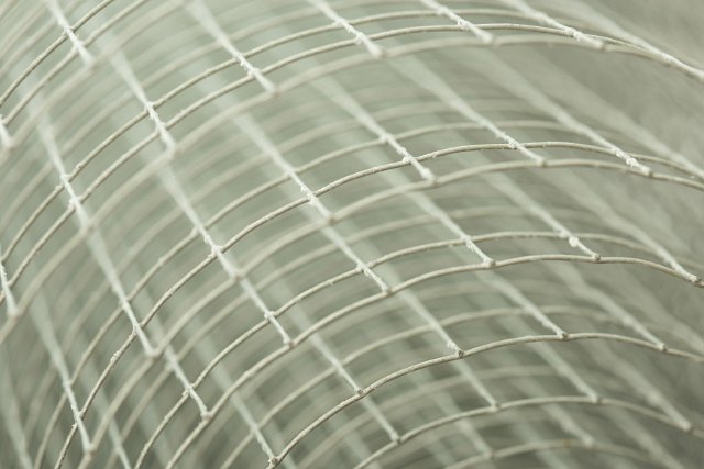 A close up detailed shot of a coiled roll of fencing wire with shallow depth of field.