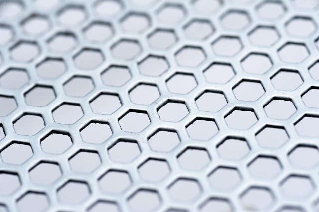 Background texture and pattern of hexagonal mesh over a white background in a full frame oblique angle view