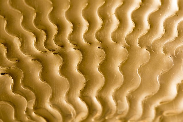 A close up, background shot of an embossed brass steel pattern.