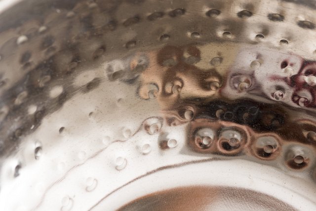 A close up abstract shot of embossed, reflective brass metal.