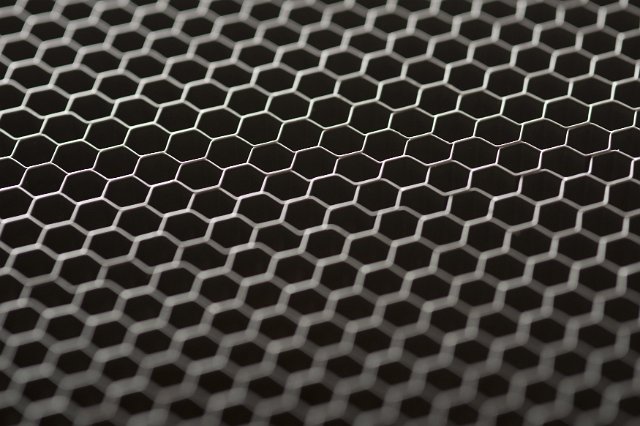 Chicken wire mesh background texture viewed at a low angel with selective focus over black