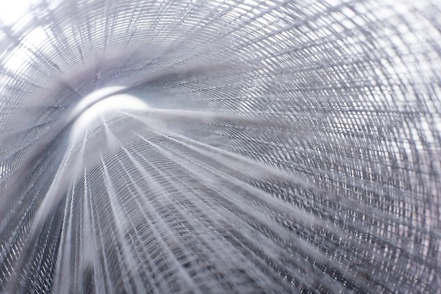 Zoom effect abstract background of a metal grid or roll of steel fencing wire giving a tube perspective