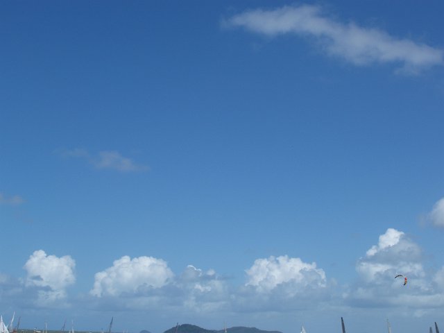 cloud scape of blue sky, clouds and the tops of sailing yacht masts