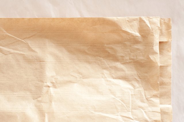 texture of a brown paper bag laid flat on a creased surface