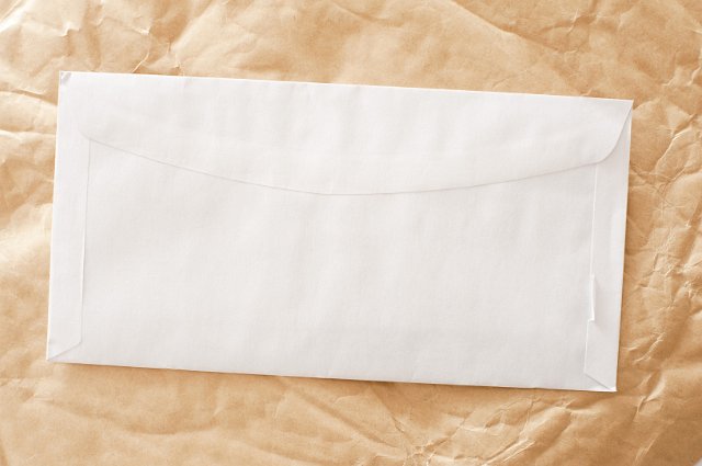 contrasting clean white envelope and a crumbled brown paper background