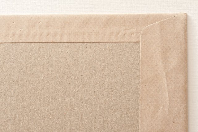 rough surface of a cardboard backed envelope with space for text and a textured paper border