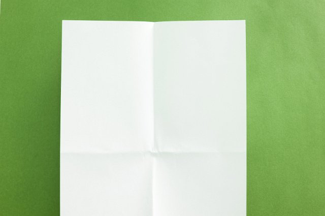 a folded sheet of paper on a green background